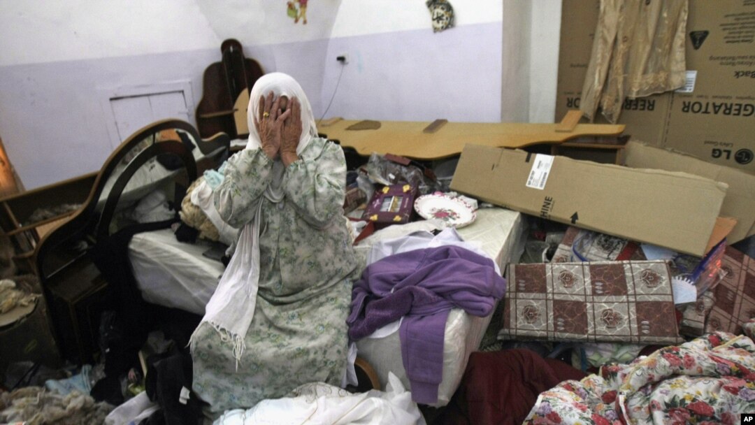 Seorang perempuan Palestina menangis di rumahnya setelah tentara Israel menggeledah rumahnya untuk mencari remaja Israel yang diculik.