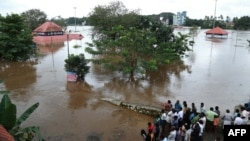 Indian residents look at the Shiva Temple submerged after the release of water from Idamalayar dam following heavy rains in Kochi on Aug. 9, 2018.