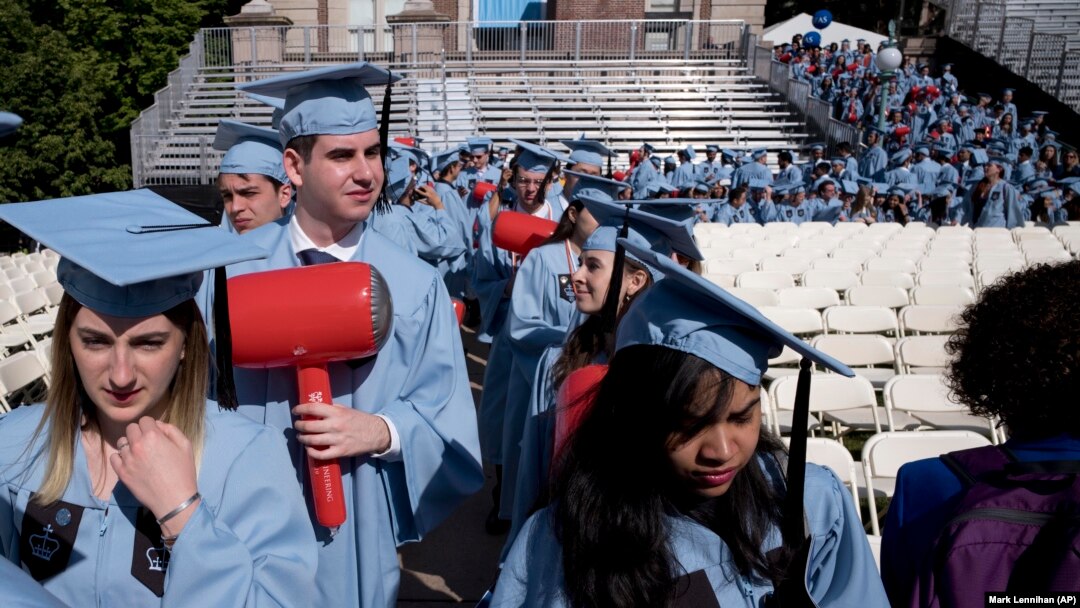FILE - Students in the engineering department carry toy hammers as they arrive to receive their degrees at Columbia University's commencement May 22, 2019 in New York. (AP Photo/Mark Lennihan)