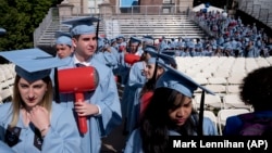 FILE - Students in the engineering department carry toy hammers as they arrive to receive their degrees at Columbia University's commencement May 22, 2019 in New York. (AP Photo/Mark Lennihan)