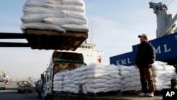 FILE - A South Korean farmer looks at packs of rice for North Korea being loaded onto a ship at Incheon port in Incheon, South Korea.