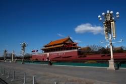 FILE - In this Feb. 16, 2020, photo, a policeman stands guard at Tiananmen Gate following the coronavirus outbreak, in Beijing.