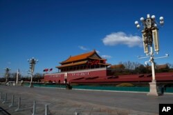 FILE - In this Feb. 16, 2020, photo, a policeman stands guard at Tiananmen Gate following the coronavirus outbreak, in Beijing.