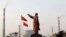 A statue of former Chinese leader Mao Zedong is seen in front of smoking chimneys at Wuhan Iron And Steel Corp in Wuhan, Hubei province, Mar. 6, 2013.