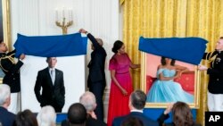 Momento en que el matrimonio de Barack y Michelle Obama revela al público los retratos que les hicieran sendos artistas estadounidenses, en la Casa Blanca, el 7 de septiembre de 2022.