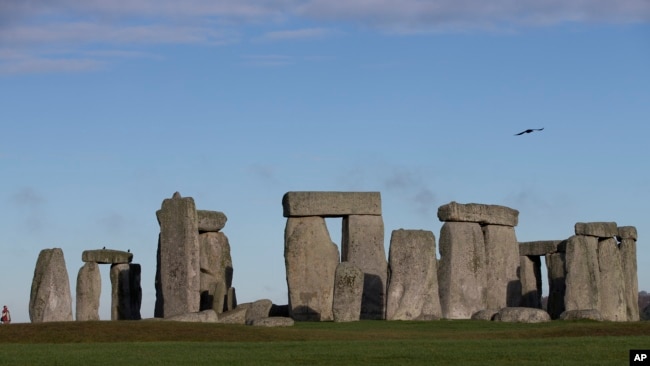 In this Tuesday, Dec. 17, 2013 file photo, visitors take photographs of the world heritage site of Stonehenge, in Wiltshire England. 