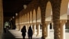 FILE- Students walk on the Stanford University campus in Santa Clara, Calif., March 14, 2019.