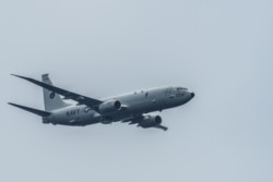 A P-8A Poseidon flies over the aircraft carrier USS Theodore Roosevelt in the Pacific Ocean, Aug. 29, 2017.