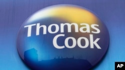 FILE - In this Tuesday, Nov. 22, 2011 file photo, a sign of Thomas Cook travel agent is seen at a branch in north London. More than 600,000 vacationers who booked through tour operator Thomas Cook were on edge Sunday, wondering if they will be able…