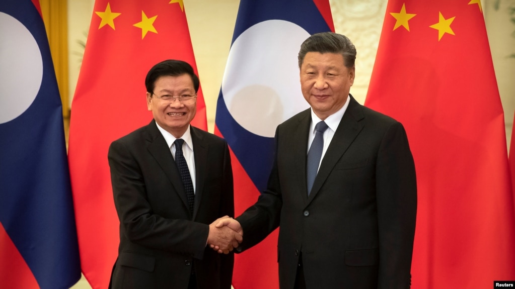 FILE - Laos' Prime Minister Thongloun Sisoulith and China's President Xi Jinping shake hands before a meeting at the Great Hall of the People in Beijing, China, Jan. 6, 2020.