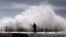 A cyclonic storm lashed Australia's east coast for a third day Wednesday, causing millions of dollars of damage to property and infrastructure. A surfer waits for a break in crashing waves before diving in for a surf off Sydney's Collaroy Beach, April 22,