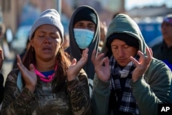 FILE—Venezuelan migrants pray at a camping site outside the Sacred Heart Church in downtown El Paso, Texas, January 8, 2023.