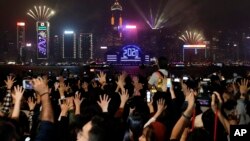 Para demonstrans mengacungkan tangan mereka sebagai simbol lima tuntutan geraka pro-demokrasi, saat perayaan malam pergantian tahun di Hong Kong, Rabu, 1 Januari 2020. (Foto: AP)