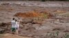 A couple with missing relatives look at the flooded area, after a dam collapsed in Brumadinho, Brazil, Jan. 26, 2019. 