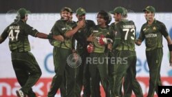 Pakistan's captain Misbah-ul-Haq (L) congrtulates Mohammad Hafeez (C) with other teammates for dismissing India's Gautam Gambhir during their Asia Cup One Day International (ODI) cricket match in Dhaka March 18, 2012. REUTERS/Andrew Biraj (BANGLADESH - Ta