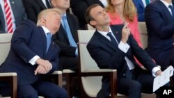 Los presidentes Donald Trump y Emmanuel Macron observan el vuelo de los aviones durante el desfile del Día de Bastilla en Paris.