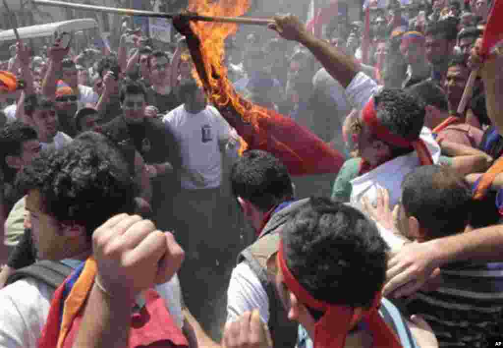 Lebanese Armenian protesters burn a Turkish flag during a protest to mark the 97th anniversary of massacres in Turkey that began in April 1915 and in which hundreds of thousands of Armenians died, in front the Turkish embassy, in Rabiyeh north of Beirut, 