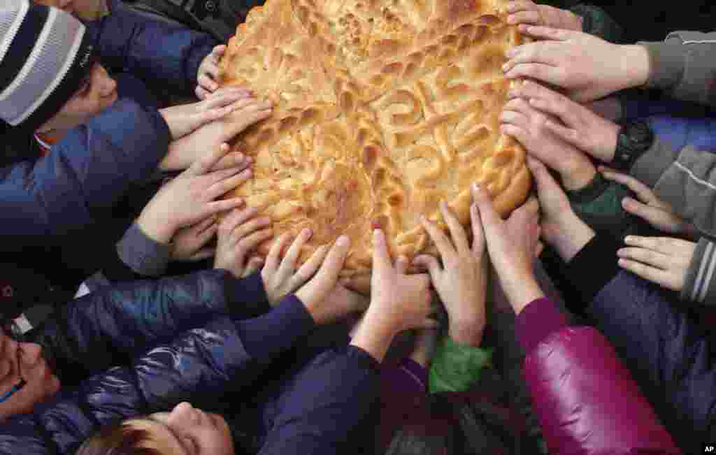 Bosnian Serb children break the traditional Christmas bread to mark Orthodox Christmas Day festivities in Banja Luka ,140 kilometers northwest of Sarajevo, Bosnia, Saturday, Jan. 7, 2012.  (AP)