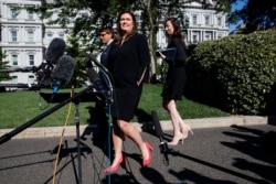 White House press secretary Sarah Sanders talks with reporters outside the White House, June 11, 2019, in Washington.
