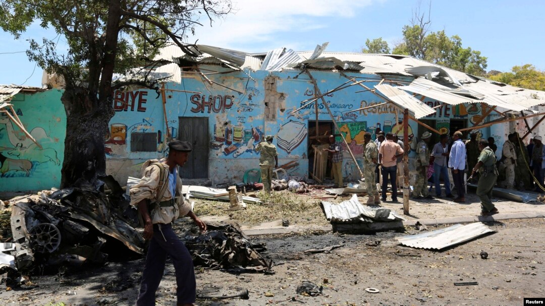 Seorang polisi berjalan di lokasi ledakan bom bunuh diri di dekat kedai teh di Mogadishu (27/2).
