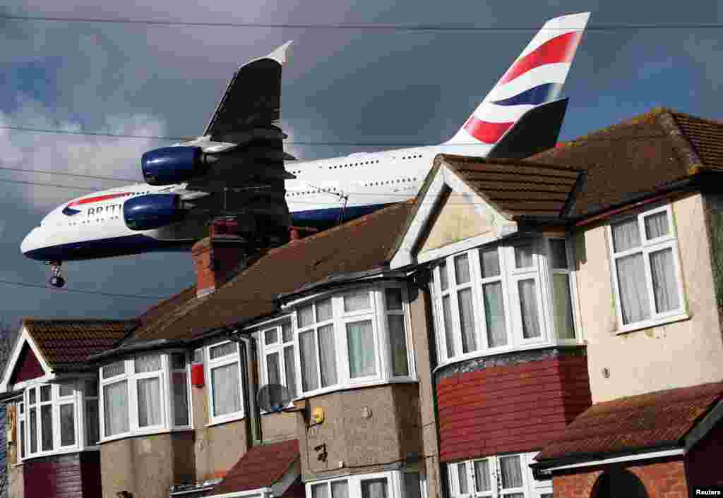 A British Airways Airbus A380 aircraft flies over the top of houses to land at Heathrow Airport in west London.