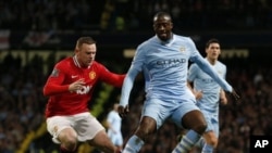 Yaya Toure na Manchester City (dama) yana kokawar kwallo da Wayne Rooney na Manchester United a karawar battar da suka yi litinin 30 Afrilu 2012, a filin wasa na Etihad dake birnin Manchester a Ingila, inda City ta doke United da ci 1-0.