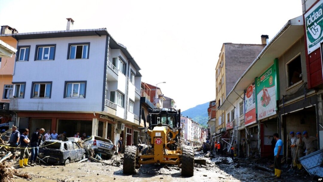 Workers clear mud from a street in Bozkurt town, Kastamonu province, Turkey, Aug. 14, 2021. The death toll from severe floods and mudslides in coastal Turkey was near 60, the country's emergency and disaster agency said.