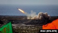 IRAN -- Iranian military fires a missile targeting a mock-up of U.S. aircraft carrier in the strategic Strait of Hormuz, July 28, 2020.