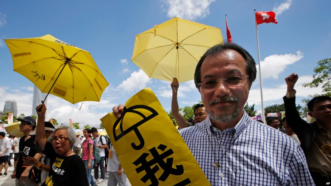 Para demonstran pro-demokrasi memegang payung kuning dalam demonstrasi di luar Dewan Legislatif Hong Kong (17/6). (AP/Kin Cheung)