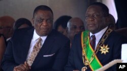 Zimbabwean President Emmerson Mnangagwa right, sits with his Deputy Constantino Chiwenga during a Heroes' Day event to commemorate the lives of those who died in the southern African country's 1970s war against white minority rule, in Harare, Aug. 13, 201