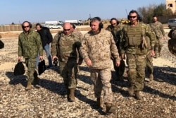 FILE - Gen. Frank McKenzie, center front, the top U.S. commander for the Middle East, visits a military outpost in Syria, Jan. 25, 2020.