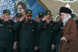 FILE- In this picture released by an official website of the office of the Iranian supreme leader, Supreme Leader Ayatollah Ali Khamenei, right, arrives at a graduation ceremony of the Revolutionary Guard's officers, in Tehran, Iran.
