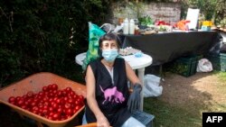 Luz Marina Salgado, una de las propietarias de Mamey, una microempresa que produce frutas, verduras y alimentos orgánicos y hace entregas a domicilio, posa junto a un carro con tomates, en Tumbaco, Quito, el 26 de marzo de 2020 durante la pandemia.