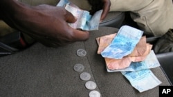 Some economists say ending the peg between CFA francs, shown here on a bus in Abidjan, and the euro would help West and Central African economies. 