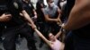 FILE - Riot police detain a demonstrator as LGBTQ rights activists try to gather for a Pride parade, which was banned by local authorities, in central Istanbul, Turkey, on June 26, 2021. 