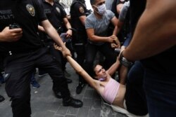 FILE - Riot police detain a demonstrator as LGBT rights activists try to gather for a Pride parade, which was banned by local authorities, in central in Istanbul, Turkey, June 26, 2021.