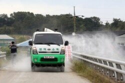 FILE - Disinfectant solution is sprayed from a vehicle as a precaution against African swine fever near a pig farm in Paju, South Korea, Sept. 20, 2019.