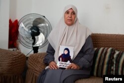 FILE —Sameera Dwayyat, the mother of Shorouq Dwayyat, 26, a female Palestinian prisoner serving a 16-year sentence, holds a picture of her daughter, in Jerusalem, November 22, 2023.