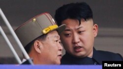 Lãnh tụ Triều Tiên Kim Jong Un nói chuyện với Choe Ryong Hae, Tổng thư ký Đảng Lao động, trong một cuộc diễu hành kỷ niệm 60 năm chiến tranh Triều Tiên, Bình Nhưỡng, 27/7/2013.