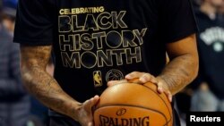 Yon jwè baskètbòl nan Boston ki gen yon mayo ki ekri Black History Month, ki vle di mwa yo selebre Istwa Moun Nwa yo Ozetazini. Foto: Premye fevriye 2017. 