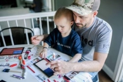 A father and son work together on a children’s flag kit from Flags of Valor in Ashburn, Virginia. (Photo courtesy Flags of Valor)