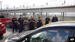 Customs and Border Protection agents survey cars entering the U.S., on the Puerta Mexico international bridge in Matamoros, Tamaulipas state, Mexico, June 28, 2019. 