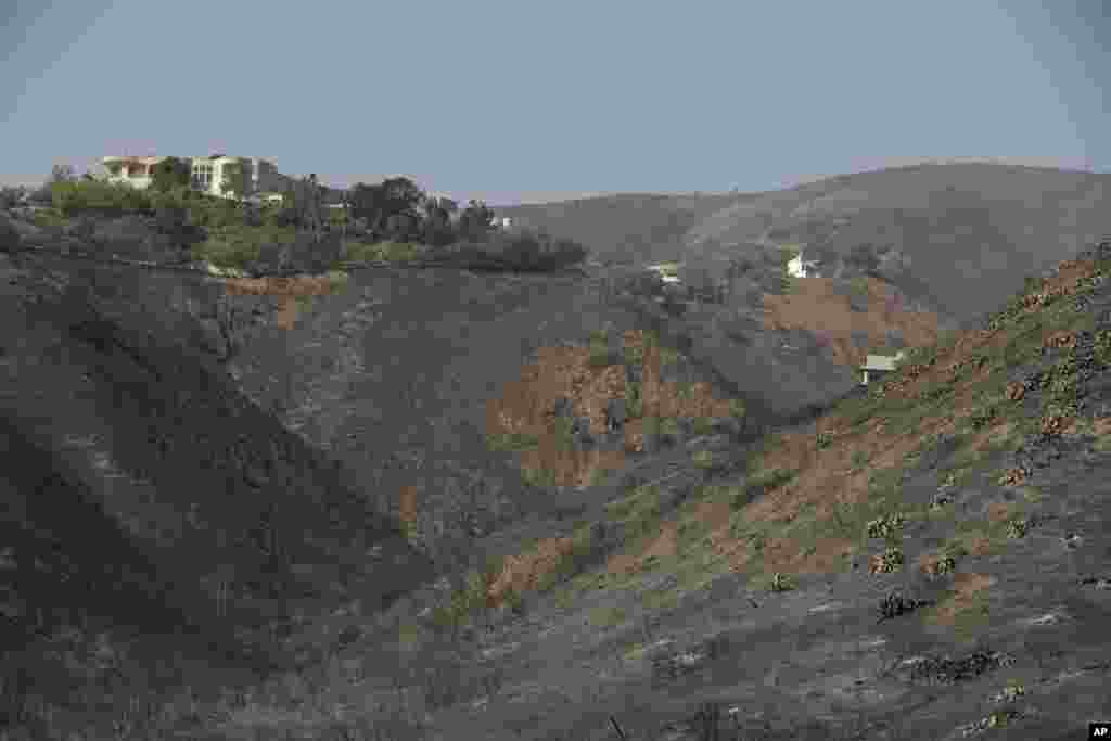 A home stands alone, at left, among the devastation left behind by a wildfire, Nov. 12, 2018, in Malibu, California. 