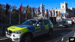 Un automóvil policial pasa frente a la Plaza del Parlamento antes de la cumbre de la OTAN en Londres, el lunes, 2 de diciembre de 2019.