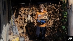 Artem Yarema, de 13 años, recolecta madera para el invierno cerca de su casa en Moshchun, cerca de Kiev, Ucrania, el 10 de octubre de 2023.