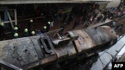 Des pompiers et des badauds sur le lieu d'accident de train au Caire, Egypte, le 27 février 2019.