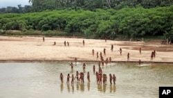 This June 2024 photo provided by Survival International shows members of the Mashco Piro along the Las Piedras River in the Peruvian Amazon near the community of Monte Salvado, in Madre de Dios province, Peru. (Survival International via AP)