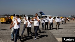 Guatemalan migrants walk on the tarmac after being deported from the U.S., at La Aurora International Airport in Guatemala City, Nov. 21, 2019. Among them was the first Honduran asylum-seeker to be flown to Guatemala under an accord with the U.S.