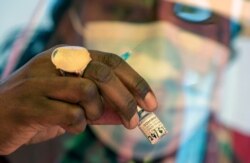 Seorang petugas kesehatan menyiapkan vaksin virus corona Pfizer pada program vaksinasi massal yang baru dibuka untuk lansia di pusat vaksinasi drive-thru di Johannesburg, Afrika Selatan, Selasa, 25 Mei 2021. (Foto: AP/Themba Hadebe)