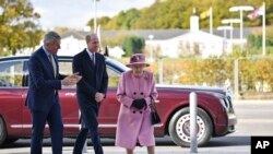 Britain's Queen Elizabeth II and Prince William speak with Chief Executive Gary Aitkenhead during a visit to the Defence Science and Technology Laboratory (DSTL) at Porton Down, Britain, Oct. 15, 2020.